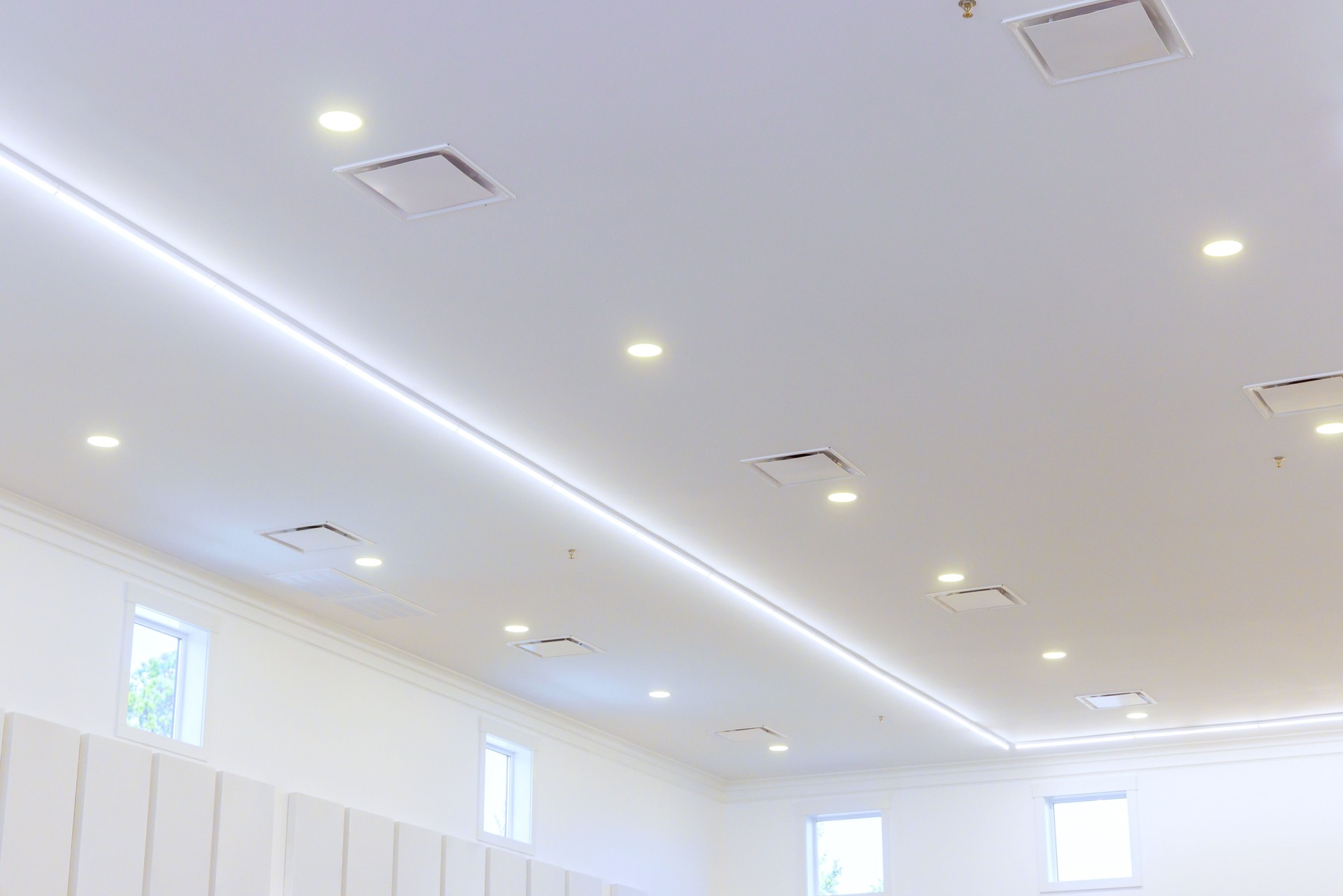 Brightly lit indoor space with modern ceiling design and ambient lighting features